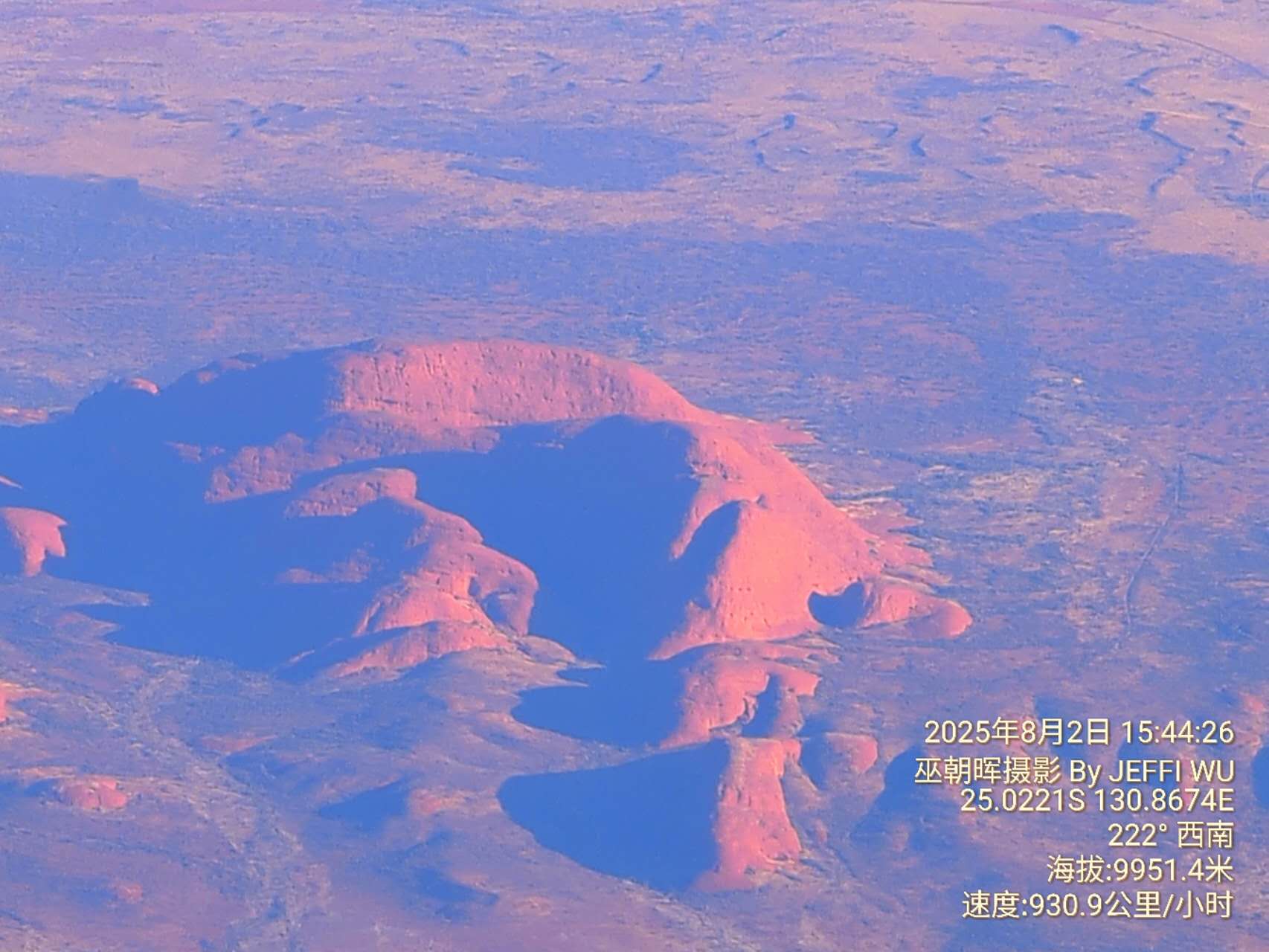 2 August 2025. The author photographed the broader Kata Tjuta landform system from an altitude of approximately 9,952 metres while flying over central Australia. The image illustrates the spatial relationship between the rock formations and the surrounding desert terrain.